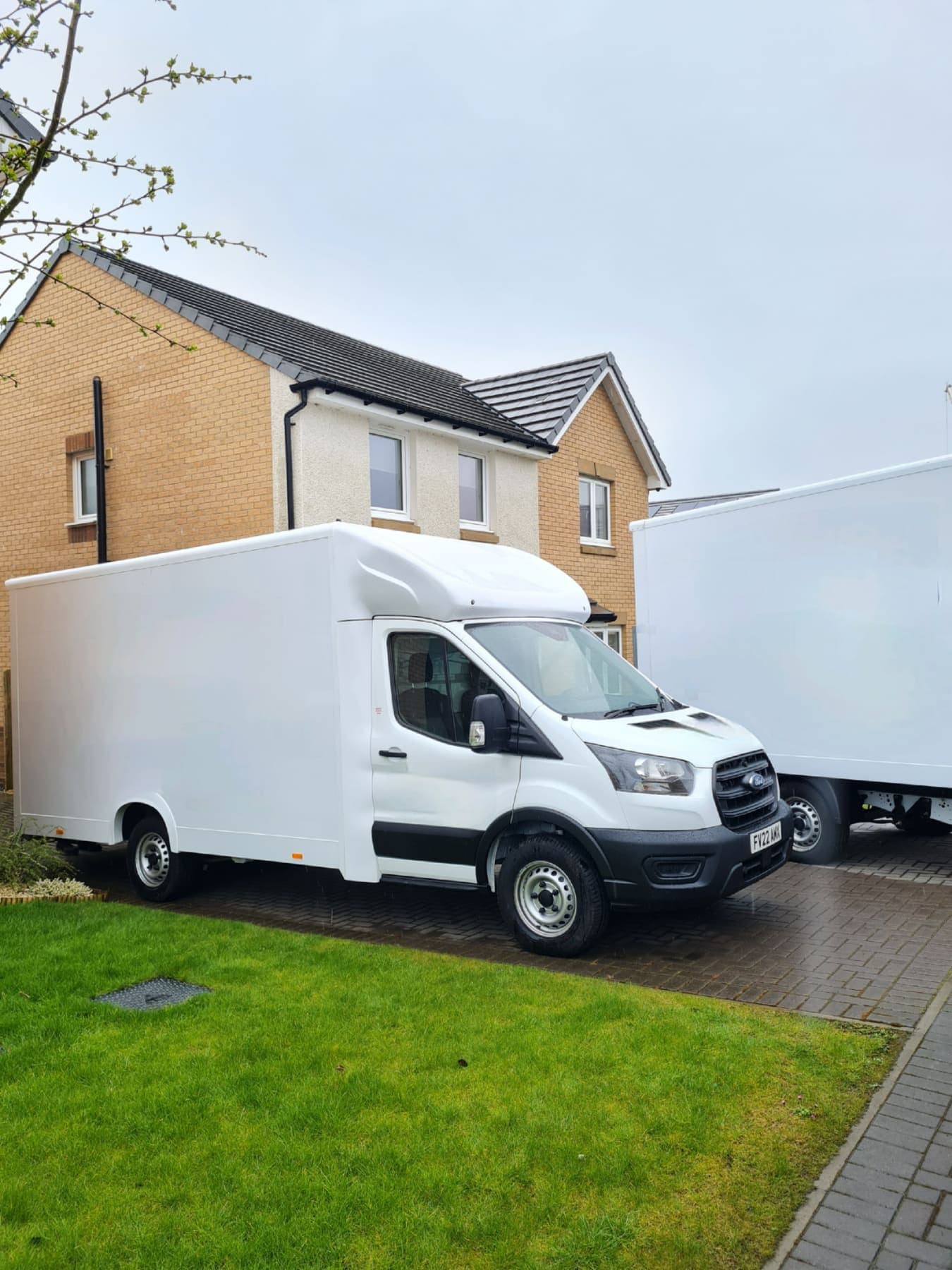 Two TransScot removal vans parked on the driveway of a house